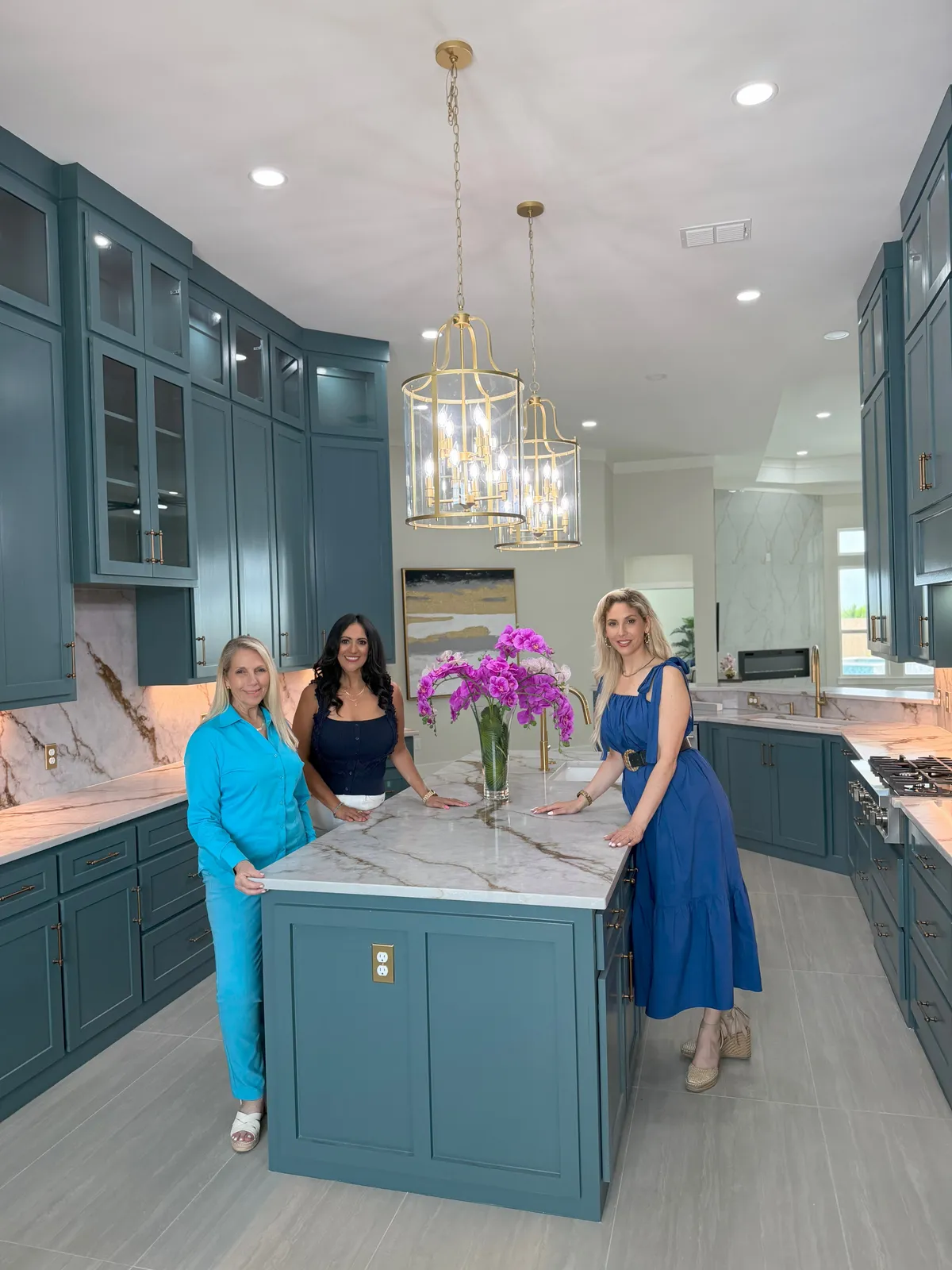 Three women in a freshly staged, sunlit kitchen during a real estate content shoot